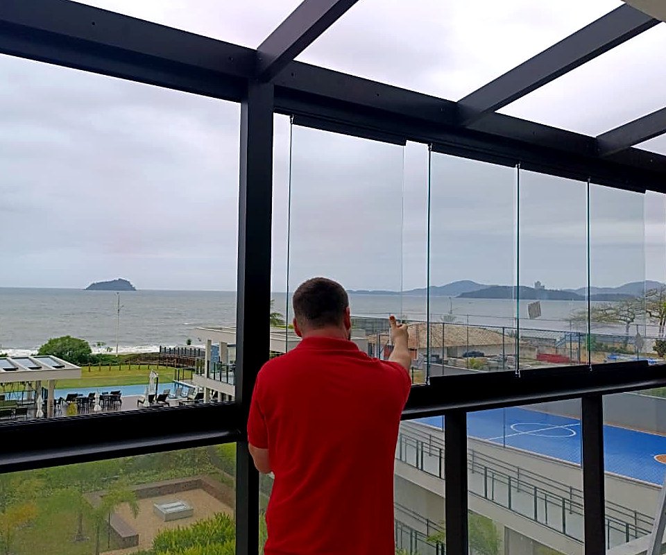 Instalação de cortina de vidro CLAROFLEX em sacada com vista para o mar